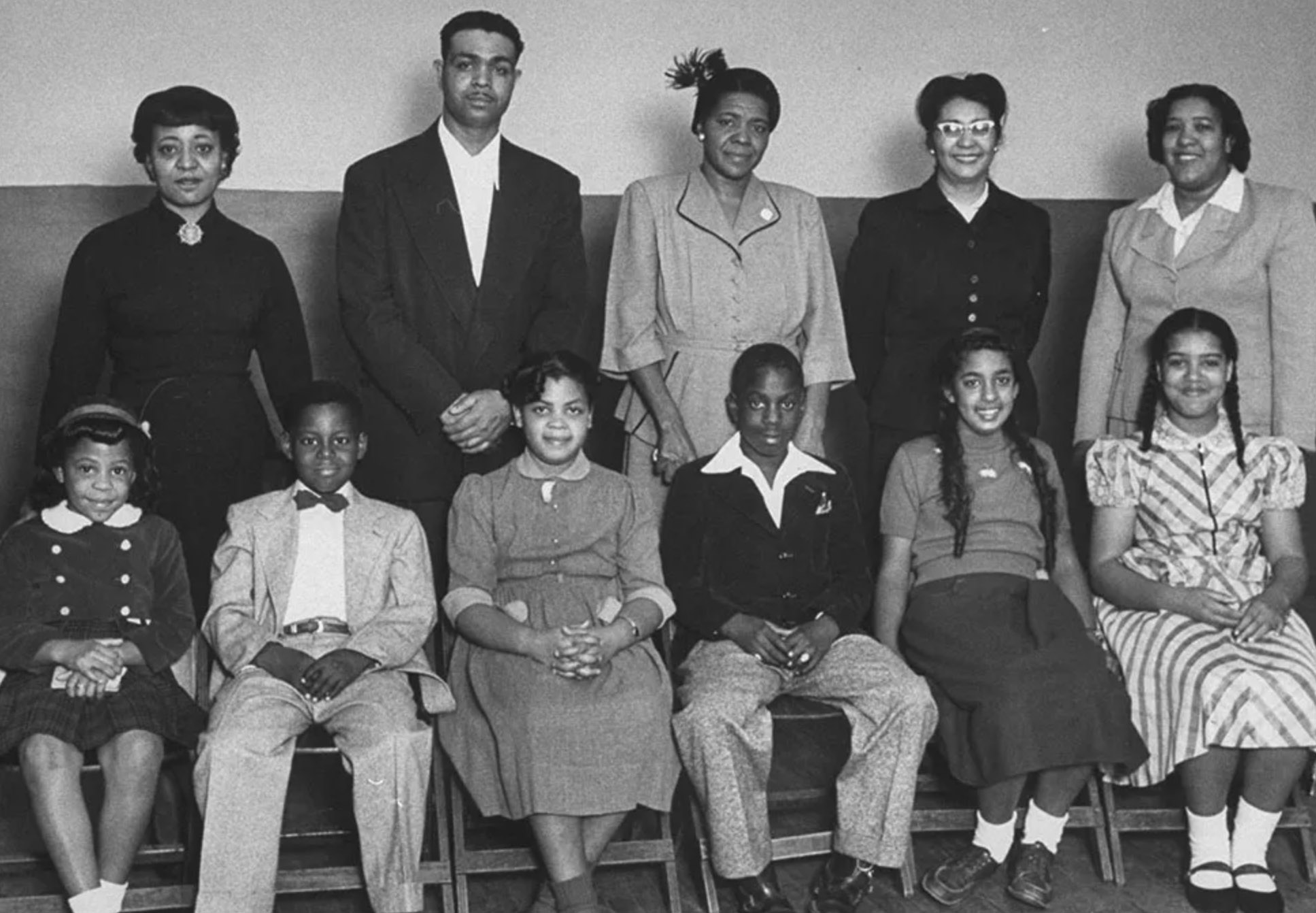 Linda Brown is seated third from the left. Her father, Oliver Brown, is standing second from the left.